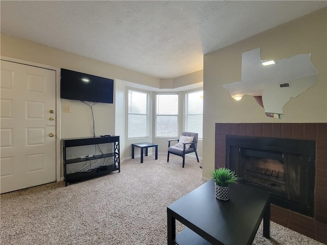 living room featuring carpet floors, a textured ceiling, and a fireplace