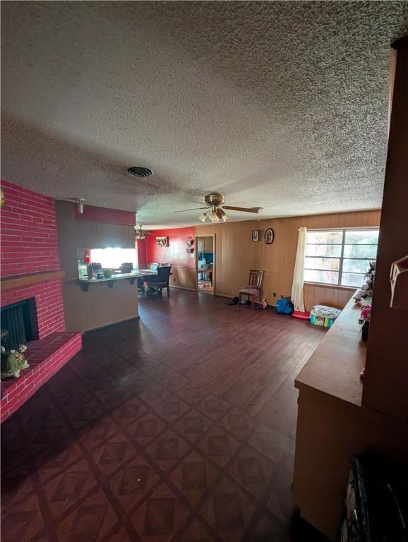 812 Victoria St, Navasota, TX 77868 - living area with a ceiling fan, plenty of natural light, a textured ceiling, and a fireplace