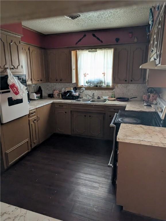 812 Victoria St, Navasota, TX 77868 - kitchen featuring black range with electric stovetop, white oven, tasteful backsplash, light countertops, and under cabinet range hood