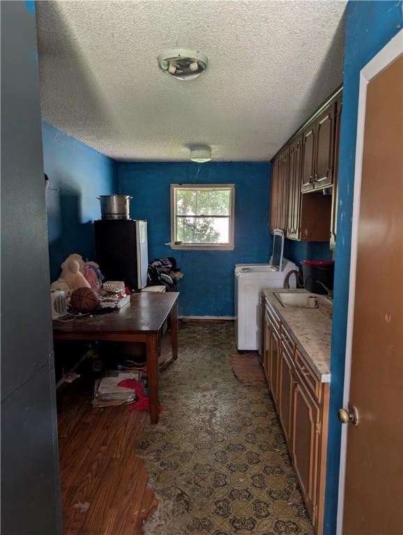 812 Victoria St, Navasota, TX 77868 - laundry area with cabinet space, a textured ceiling, washer and clothes dryer, and dark wood-style floors