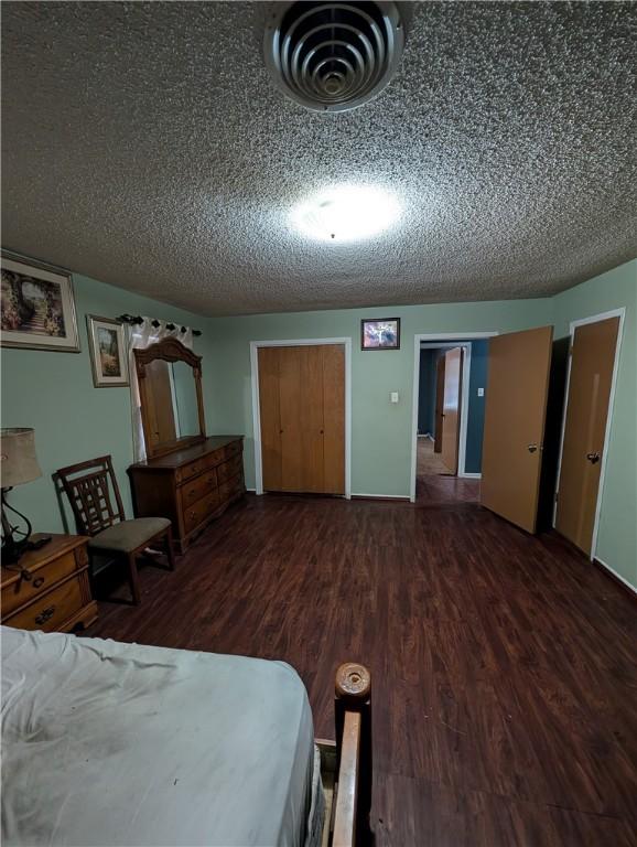 812 Victoria St, Navasota, TX 77868 - bedroom with wood finished floors and a textured ceiling
