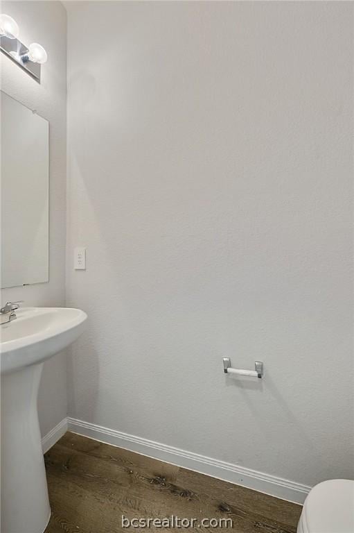 bathroom featuring sink, wood-type flooring, and toilet