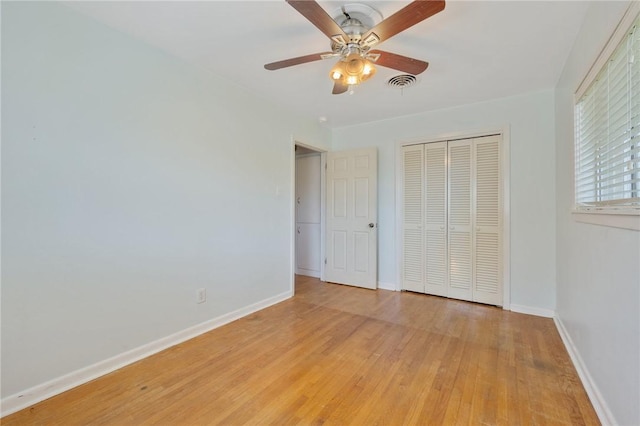unfurnished bedroom with light wood-style flooring, a closet, baseboards, and ceiling fan
