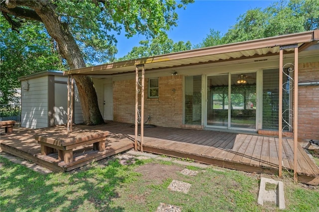 back of property with brick siding and a wooden deck