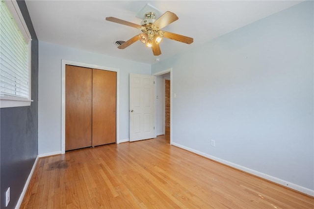 unfurnished bedroom with baseboards, light wood-type flooring, a closet, and ceiling fan