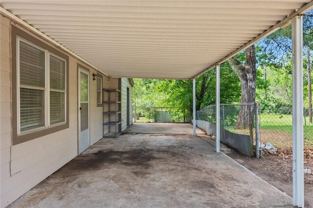 view of patio featuring fence and a carport