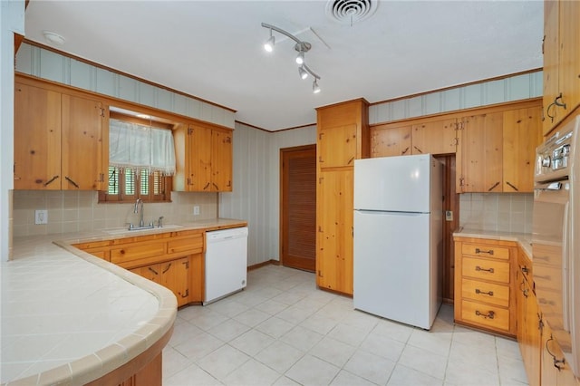 kitchen featuring white appliances, a sink, tile countertops, and tasteful backsplash
