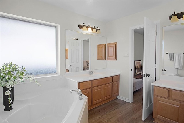 bathroom featuring a bathing tub, hardwood / wood-style floors, and vanity