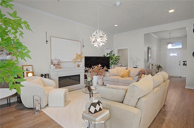 living room featuring hardwood / wood-style flooring, an inviting chandelier, and crown molding