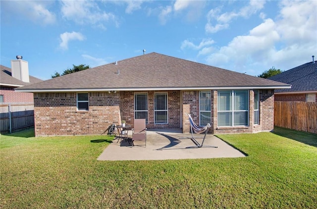 rear view of house with a lawn and a patio