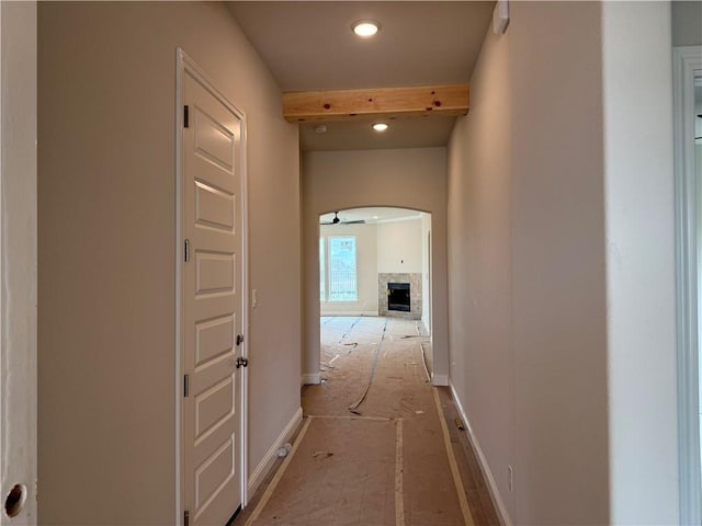 hallway with recessed lighting, beamed ceiling, and arched walkways