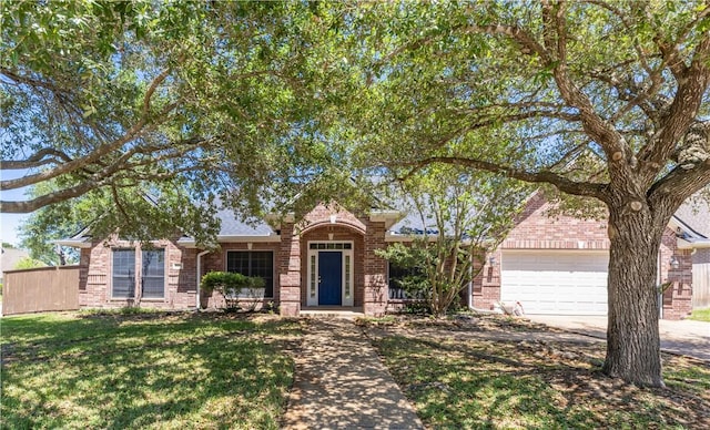 single story home with an attached garage, concrete driveway, a front lawn, and brick siding