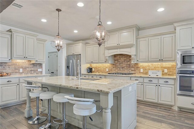 4111 Downton Abbey Ave, College Station, TX 77845 - kitchen with a sink, light wood finished floors, appliances with stainless steel finishes, and tasteful backsplash