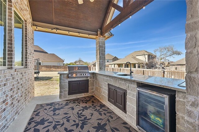 4111 Downton Abbey Ave, College Station, TX 77845 - view of patio / terrace featuring fence, exterior kitchen, beverage cooler, a sink, and a grill