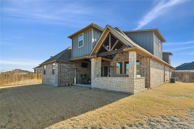 4111 Downton Abbey Ave, College Station, TX 77845 - rear view of property featuring central AC, a fenced backyard, brick siding, board and batten siding, and a lawn