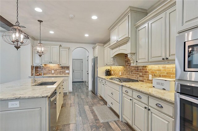 4111 Downton Abbey Ave, College Station, TX 77845 - kitchen featuring wood finished floors, light stone countertops, tasteful backsplash, a sink, and stainless steel appliances