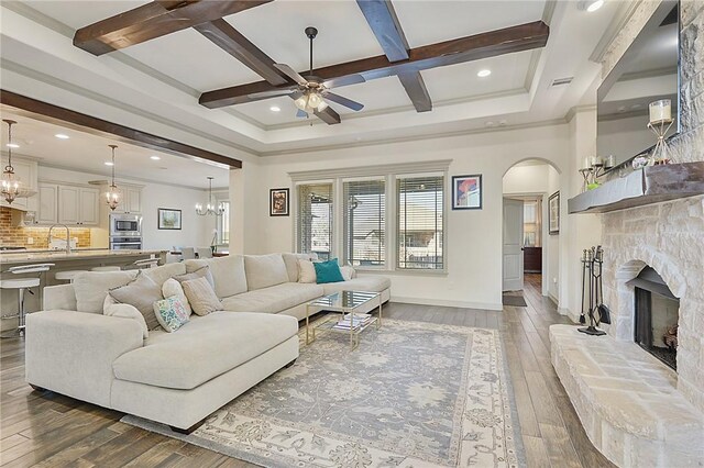 4111 Downton Abbey Ave, College Station, TX 77845 - living area featuring wood-type flooring, beamed ceiling, baseboards, arched walkways, and ceiling fan with notable chandelier