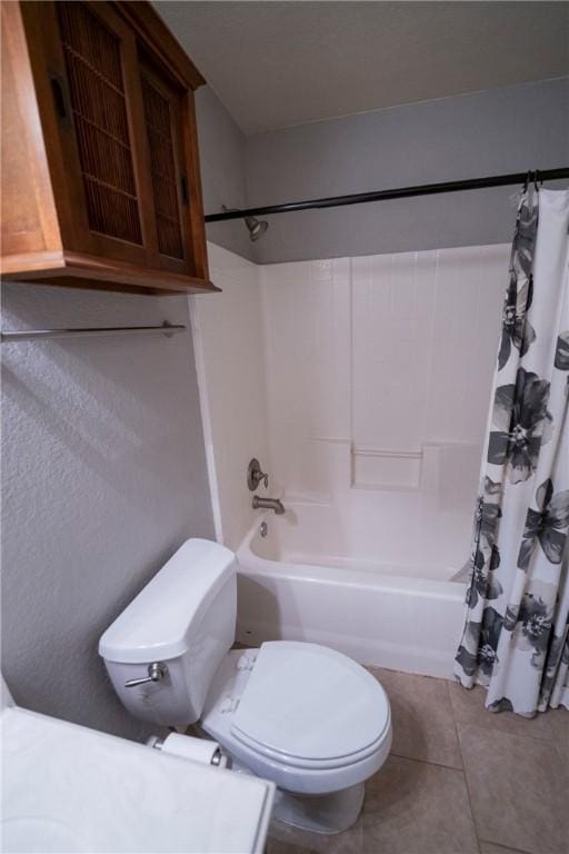 bathroom with tile patterned flooring, shower / bath combo, and toilet