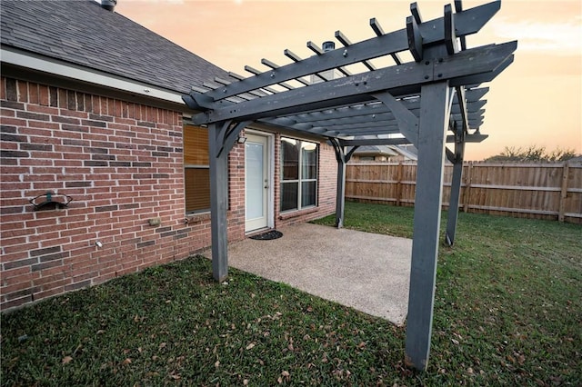 patio terrace at dusk with a pergola and a yard