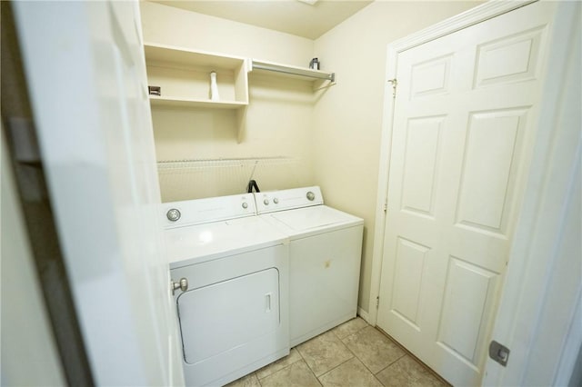 clothes washing area featuring washer and clothes dryer and light tile patterned flooring