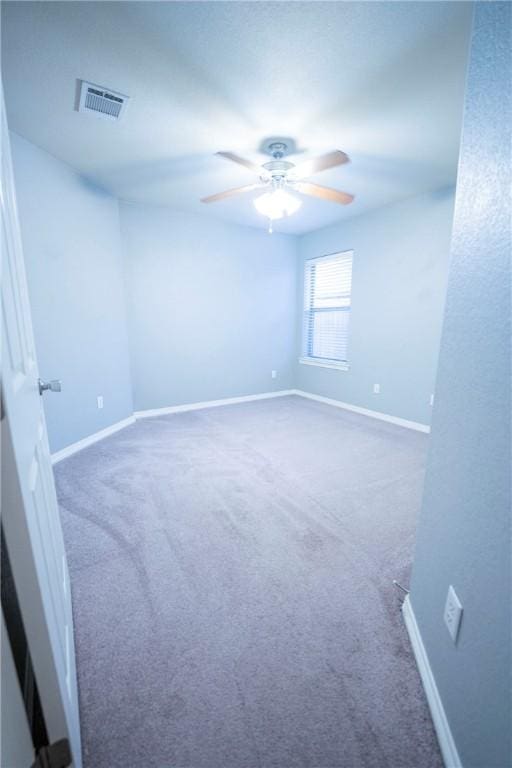 spare room with dark colored carpet and ceiling fan