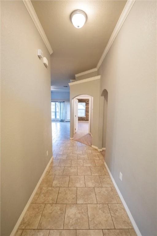 corridor with light tile patterned floors and crown molding