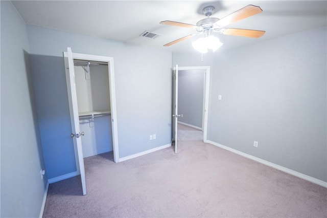 unfurnished bedroom with ceiling fan, light carpet, and a closet