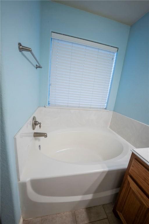 bathroom featuring tile patterned flooring, vanity, and a bath