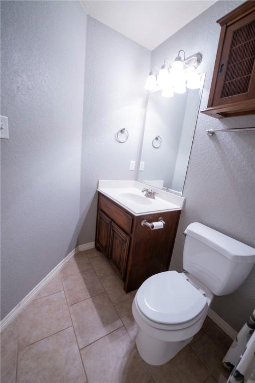 bathroom featuring tile patterned floors, vanity, and toilet