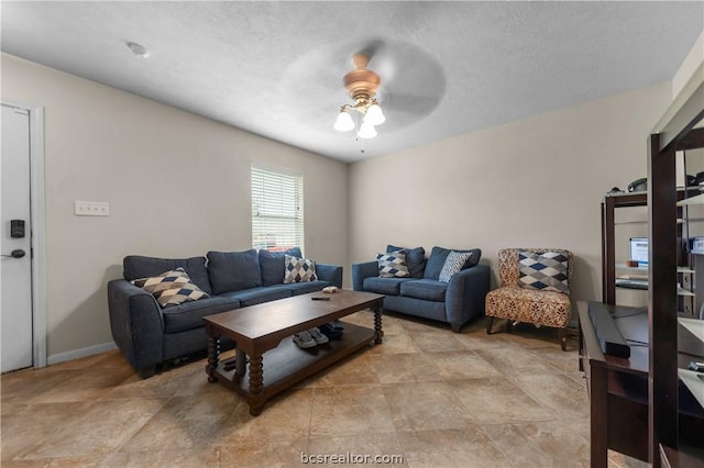 living room with ceiling fan and a textured ceiling