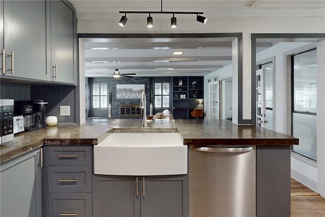 kitchen featuring gray cabinetry, ceiling fan, sink, and stainless steel dishwasher