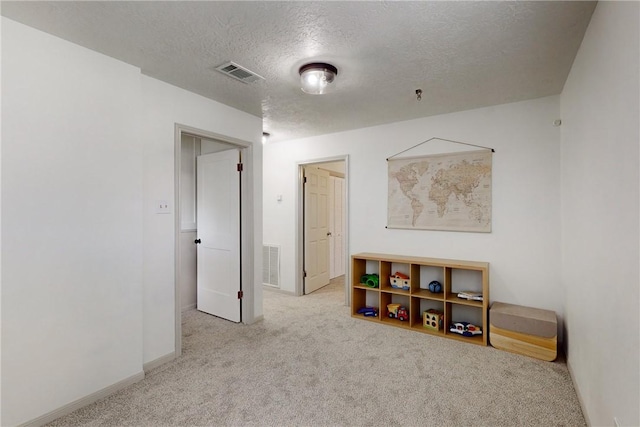 game room featuring light carpet and a textured ceiling