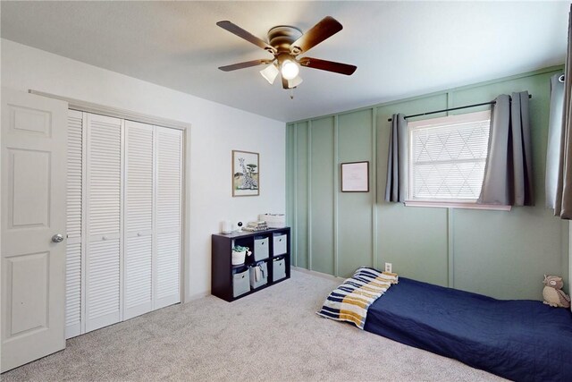 bedroom featuring light carpet, a closet, and ceiling fan