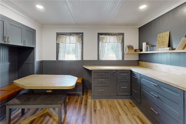 kitchen featuring breakfast area, gray cabinets, light wood-type flooring, and ornamental molding