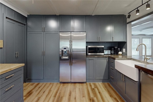 kitchen with gray cabinets, sink, appliances with stainless steel finishes, and wooden counters