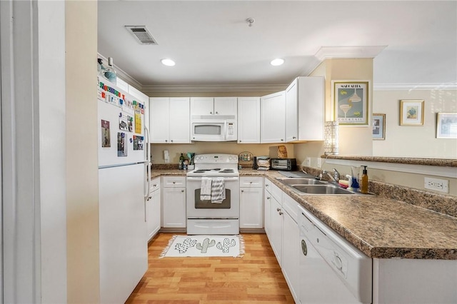 kitchen with visible vents, crown molding, a sink, white appliances, and light wood-style flooring