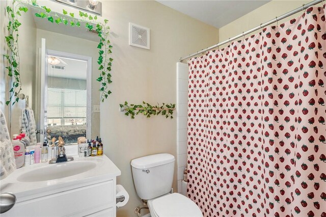 bathroom featuring vanity, toilet, and visible vents
