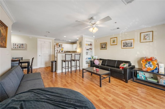 living room featuring visible vents, ornamental molding, light wood-type flooring, recessed lighting, and a ceiling fan