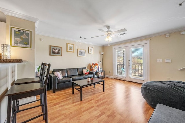 living area with ceiling fan, french doors, light wood-type flooring, visible vents, and ornamental molding