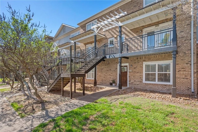 back of house featuring stairs and brick siding