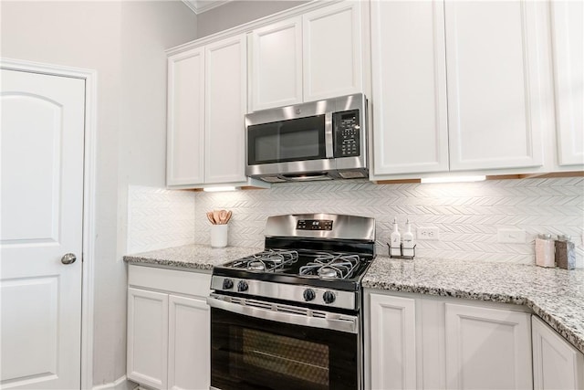 kitchen with white cabinets, decorative backsplash, light stone counters, and appliances with stainless steel finishes