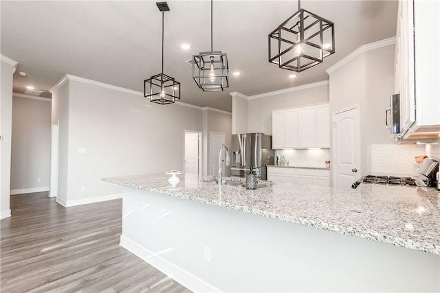 kitchen featuring kitchen peninsula, tasteful backsplash, sink, pendant lighting, and white cabinets