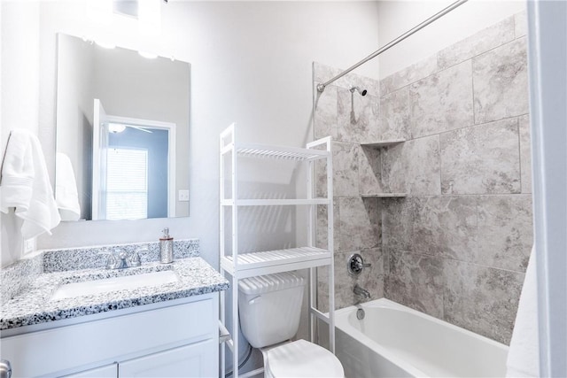 full bathroom featuring vanity, tiled shower / bath combo, and toilet