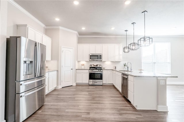 kitchen featuring light stone countertops, white cabinetry, hanging light fixtures, and appliances with stainless steel finishes