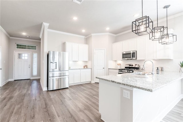 kitchen with white cabinetry, stainless steel appliances, kitchen peninsula, decorative light fixtures, and light wood-type flooring