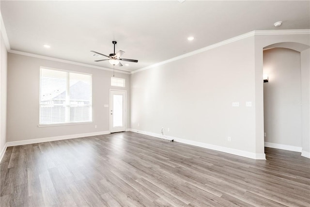 empty room with ceiling fan, hardwood / wood-style flooring, and ornamental molding