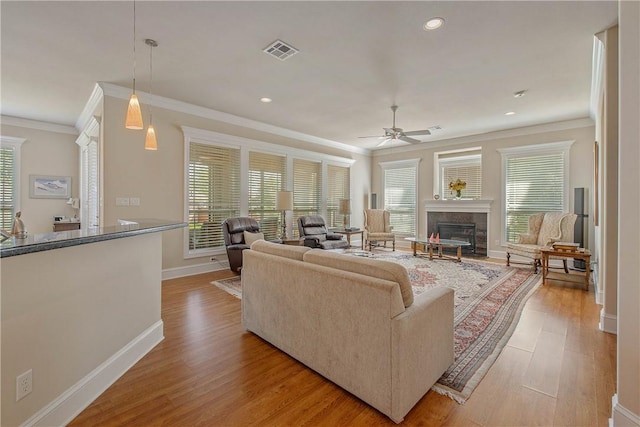 living room featuring ceiling fan, light hardwood / wood-style flooring, and ornamental molding