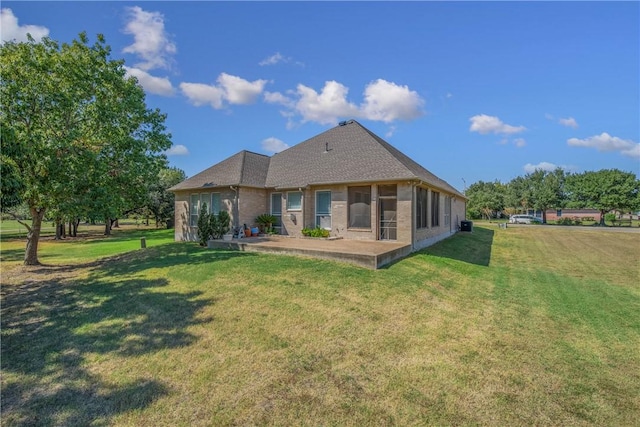 rear view of house with a yard and a patio