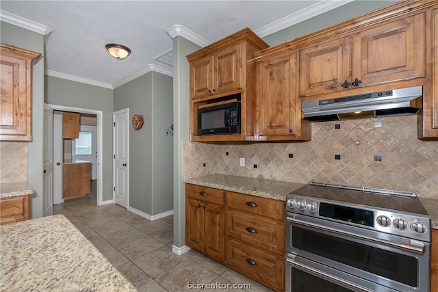 kitchen with tasteful backsplash, crown molding, light stone counters, and range with two ovens