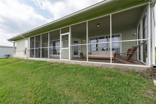 back of house with a lawn and a sunroom